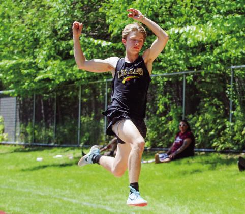 Leland senior Logan DeFour soars in the long jump during a regional track meet at East Jordan on Saturday.