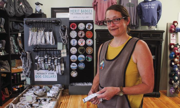 Meg Paxton shows off her original Petoskey Stone Dog Collars at The Blue Maple Corner in Maple City. Enterprise photo by Brian Freiberger