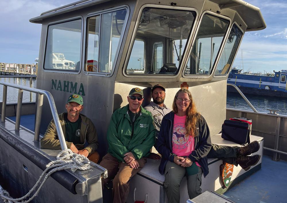 Sleeping Bear Dunes National Lakeshore volunteers (from left to right) John England, Patty Kelly, boat captain Adam Reitz, and Mandy England are pictured Wednesday morning while loading up for a two week trip to South Manitou Island. Kelly, 72, has been volunteering with the National Park Service for 36 years now, and said during this trip, they plan to complete groundskeeping and maintenance projects on the farm and around the island. Enterprise photo by Meakalia Previch-Liu